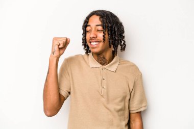 Genç Afrikalı Amerikalı adam beyaz arka planda izole edilmiş zafer, tutku ve coşkuyu kutluyor, mutlu bir ifade..
