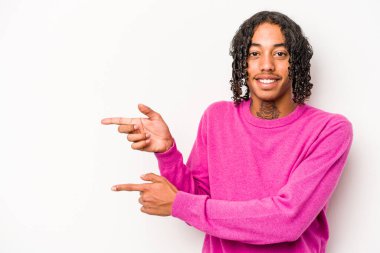 Beyaz arka planda izole edilmiş genç Afro-Amerikalı adam işaret parmağıyla işaret ettiği için heyecanlı..