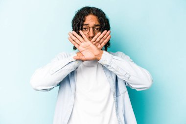 Genç Afrikalı Amerikalı adam mavi arka planda izole edilmiş bir şekilde inkar jesti yapıyor.