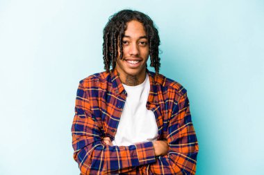 Genç Afrikalı Amerikalı adam mavi arka planda izole edilmiş gülüyor ve eğleniyor..