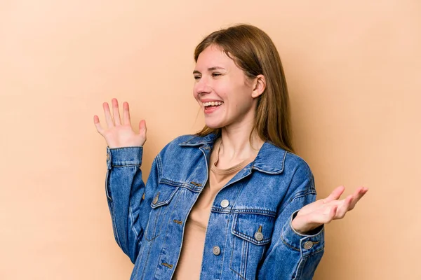 Young English woman isolated on beige background joyful laughing a lot. Happiness concept.