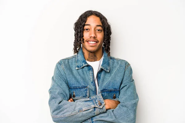 Beyaz arka planda izole edilmiş genç bir Afrikalı Amerikalı. Kendine güveniyor, kararlılıkla kollarını kavuşturuyor..