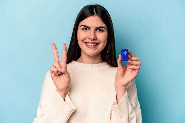 Junge Kaukasische Frau Mit Einer Batterie Auf Blauem Hintergrund Die — Stockfoto