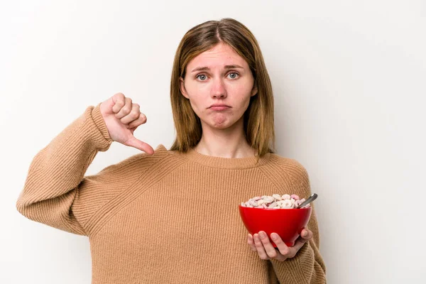 Beyaz arka planda izole edilmiş mısır gevreği yiyen genç bir İngiliz kadın hoş olmayan bir jest gösteriyor. Anlaşmazlık konsepti.