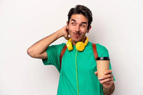 Young caucasian student man drinking coffee isolated on white background touching back of head, thinking and making a choice.