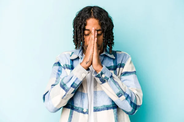 Mladý Africký Američan Izolovaný Modrém Pozadí Drží Ruce Modlitbě Blízkosti — Stock fotografie