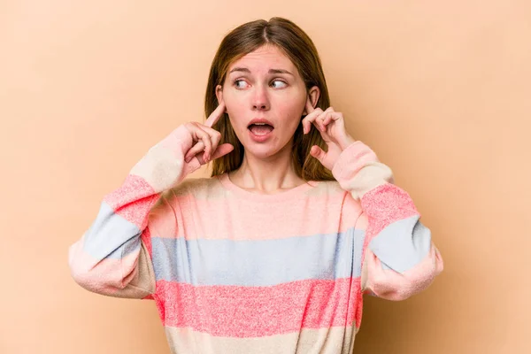 若い英語の女性は指で耳をカバーベージュの背景に隔離 強調し 大声で周囲によって絶望 — ストック写真