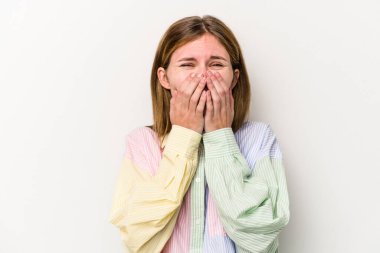 Beyaz arka planda izole edilmiş genç bir Rus kadın bir şeye gülüyor, elleriyle ağzını kapatıyor..