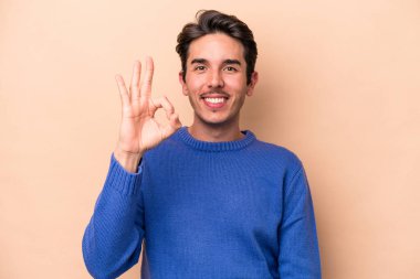 Beyaz tenli genç adam bej arka planda izole edildi. Neşeli ve kendinden emin..