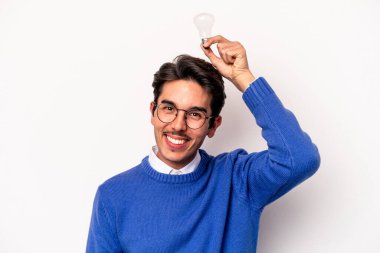 Beyaz arka planda izole edilmiş bir ampul tutan genç beyaz bir adam.