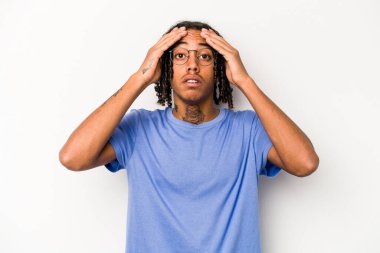 Genç Afrikalı Amerikalı adam beyaz arka planda izole edilmiş, şaşırmış ve şok olmuş..