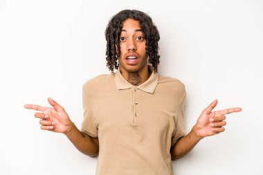 Beyaz arka planda izole edilmiş genç Afro-Amerikalı adam farklı kopya alanlarını gösteriyor, birini seçiyor, parmaklarıyla gösteriyor..
