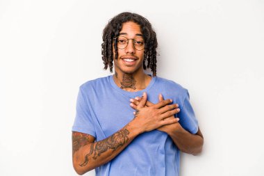Beyaz arka planda izole edilmiş genç Afro-Amerikalı bir adam dost ifadesine sahip, avuçlarını göğsüne bastırıyor. Aşk konsepti.