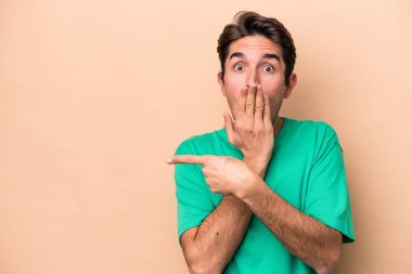 Beyazlı genç bir adam bej arka planda izole edilmiş.