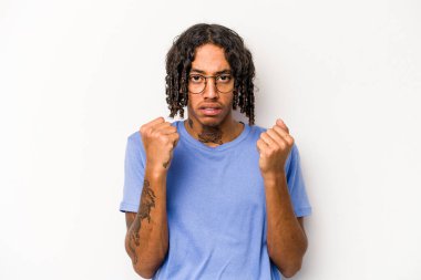 Beyaz arka planda izole edilmiş genç Afro-Amerikan adam kameraya yumruğunu gösteriyor, agresif yüz ifadesi..