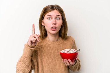 Beyaz arka planda izole edilmiş mısır gevreği yiyen genç İngiliz kadının bir fikri var, ilham verici bir kavram..