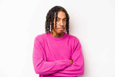 Beyaz arka planda izole edilmiş, hoşnutsuzca kaşlarını çatmış, kollarını kavuşturmuş genç Afrikalı Amerikalı bir adam..