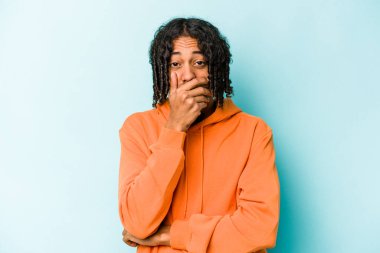 Genç Afrikalı Amerikalı adam mavi arka planda izole edilmiş korkmuş ve korkmuş..