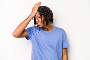 Beyaz arka planda izole edilmiş genç Afro-Amerikan bir şeyi unutuyor. Alnına avuç içi ve kapalı gözlerle vuruyor..