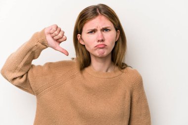 Beyaz arka planda izole edilmiş genç bir Rus kadın baş parmağını aşağı gösteriyor ve hoşlanmadığını ifade ediyor..