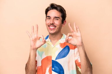 Beyaz tenli genç adam bej arka planda izole edildi. Neşeli ve kendinden emin..