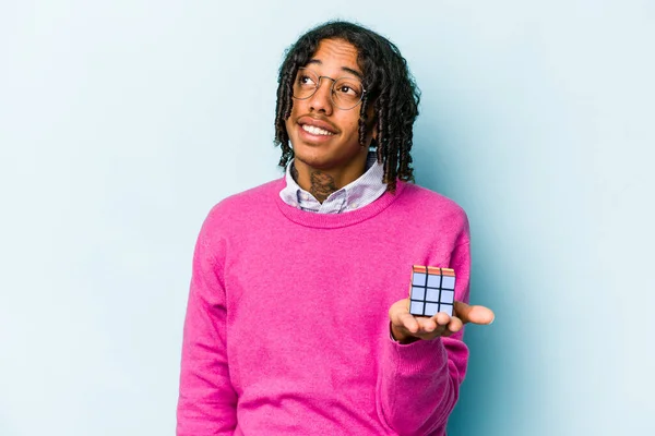 Mladý Afroameričan Drží Kostku Rubiks Izolované Modrém Pozadí Snění Dosažení — Stock fotografie