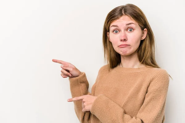 被白色背景隔离的年轻俄罗斯女人用食指指向一个复制空间震惊了 — 图库照片