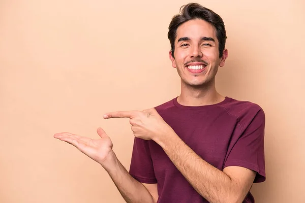 Young Caucasian Man Isolated Beige Background Excited Holding Copy Space — Stock Photo, Image