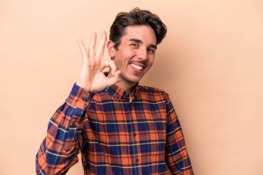 Beyaz tenli genç adam bej arka planda izole edildi. Neşeli ve kendinden emin..