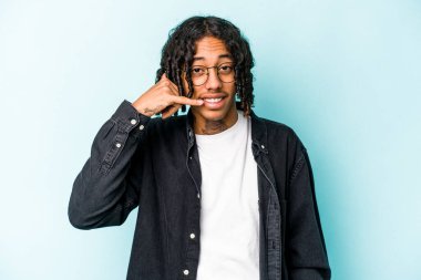 Genç Afrikalı Amerikalı bir adam mavi arka planda izole edilmiş, parmakları olan bir cep telefonu hareketi gösteriyor..