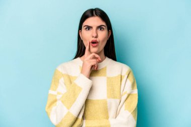 Kafkasyalı genç bir kadın mavi arka planda izole edilmiş. Harika bir fikri var, yaratıcılık kavramı..