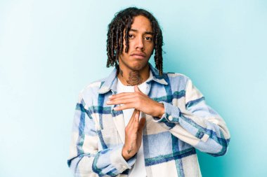 Genç Afrikalı Amerikalı bir adam mavi arka planda izole edilmiş..
