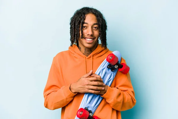 若いアフリカ系アメリカ人のスケーターの男性が青の背景に笑いと楽しみを隔離 — ストック写真