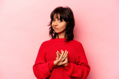 Pembe arka planda izole edilmiş genç İspanyol kadın inkar jesti yapıyor.