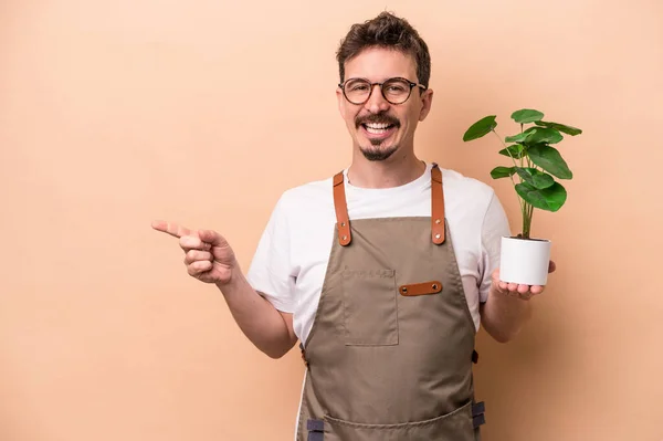 Junger Kaukasischer Gärtner Der Eine Pflanze Auf Beigem Hintergrund Isoliert — Stockfoto