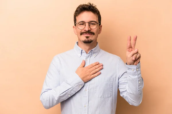 Young Caucasian Man Isolated Beige Background Taking Oath Putting Hand — Stock Photo, Image