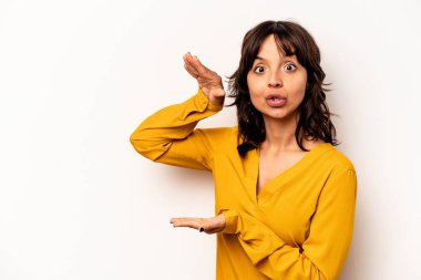 Beyaz arka planda izole edilmiş genç İspanyol kadın elleri arasında bir kopya alanı tutarken şok ve hayrete düştü..