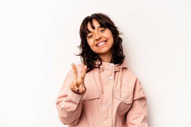 Beyaz arka planda izole edilmiş genç İspanyol kadın neşeli ve kaygısız parmakları olan bir barış sembolü gösteriyor..