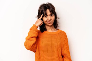 Beyaz arka planda izole edilmiş genç İspanyol bir kadın şakağı parmağıyla işaret ediyor, düşünüyor ve bir göreve odaklanıyor..