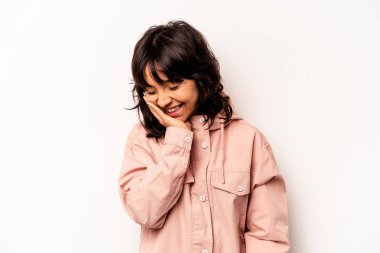 Young hispanic woman isolated on white background laughs happily and has fun keeping hands on stomach.