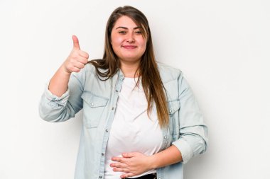 Beyaz arka planda izole edilmiş beyaz tenli genç beyaz kadın karnına dokunuyor, nazikçe gülümsüyor, yemek yiyor ve tatmin oluyor..