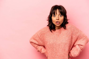 Pembe arka planda izole edilmiş genç İspanyol kadın gördüğü bir şey yüzünden şoka uğruyor..