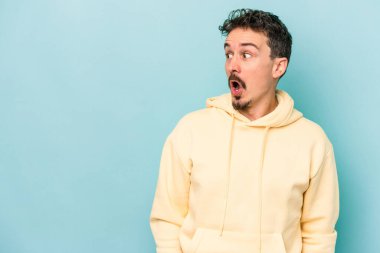 Kafkasyalı genç adam mavi arka planda izole edilmişti. Gördüğü bir şey yüzünden şok olmuştu..