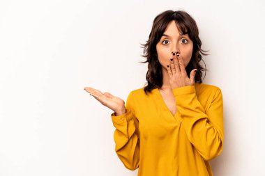 Beyaz arka planda izole edilmiş genç İspanyol kadın, avuç içi fotokopi alanı tutmaktan etkilenmiş..