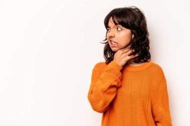 Beyaz arka planda izole edilmiş genç İspanyol kadın kafasının arkasına dokunuyor, düşünüyor ve bir seçim yapıyor..