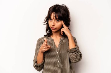 Beyaz arka planda izole edilmiş genç İspanyol bir kadın şakağı parmağıyla işaret ediyor, düşünüyor ve bir göreve odaklanıyor..