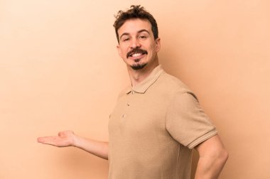 Beyazların arka planında izole edilmiş genç beyaz bir adam hoş bir ifade sergiliyor..