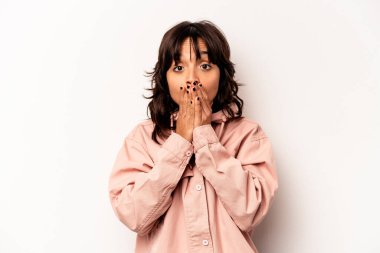 Beyaz arka planda izole edilmiş genç İspanyol kadın şok olmuş, ağzı ellerle kaplanmış, yeni bir şey keşfetmeye hevesli..