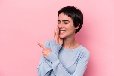 Pembe arka planda izole edilmiş genç beyaz bir kadın bir dedikodu söylüyor, bir haber sunuyor..