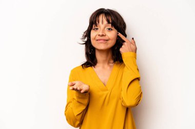 Beyaz arka planda izole edilmiş genç İspanyol kadın elinde bir ürün tutuyor ve.